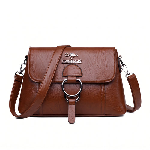 Bolsa clutch feminina transversal marrom de couro sintético com aba e argola prateada, vista de frente