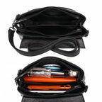 Bolsa clutch preta aberta mostrando os compartimentos internos, com celular, carteira e perfume